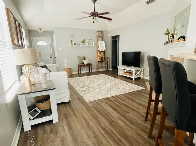 living room with ceiling fan, vaulted ceiling, and dark hardwood / wood-style flooring