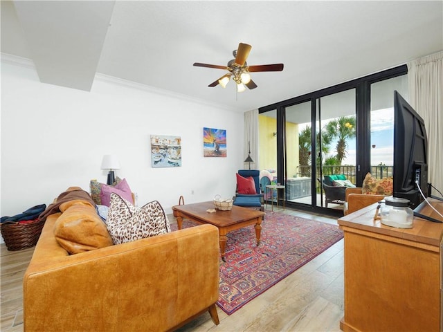 living room featuring ceiling fan, crown molding, light hardwood / wood-style flooring, and expansive windows