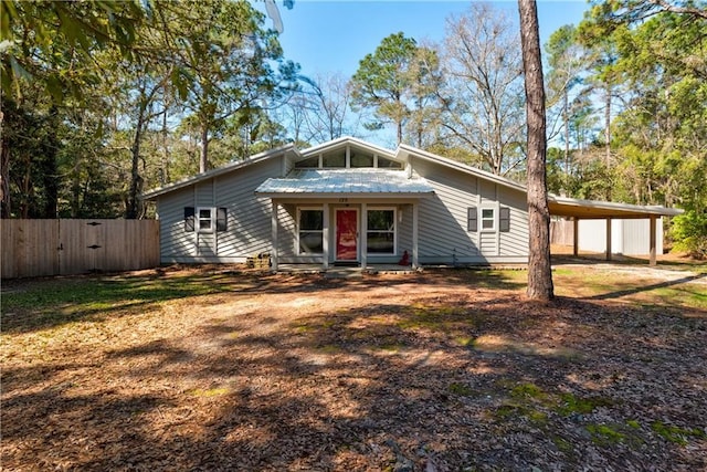 mid-century home featuring fence and an attached carport