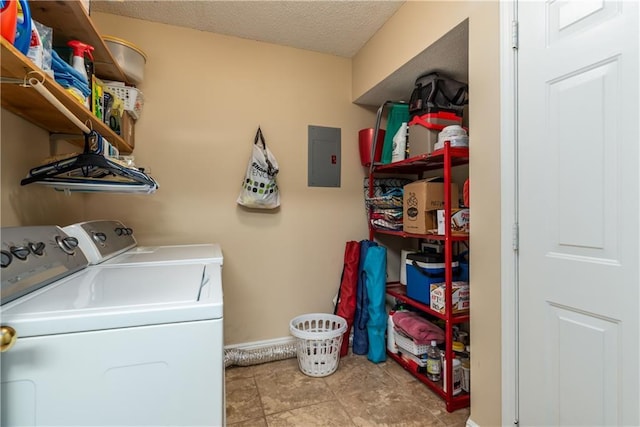 laundry area featuring washing machine and clothes dryer, a textured ceiling, laundry area, electric panel, and baseboards