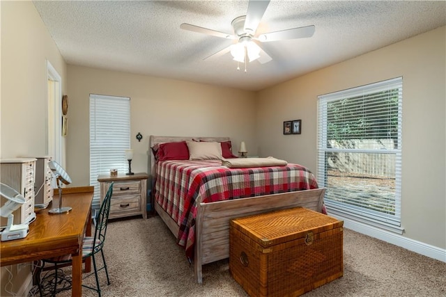 carpeted bedroom with a ceiling fan, baseboards, and a textured ceiling