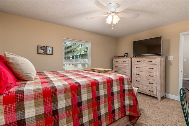 bedroom with a ceiling fan, light colored carpet, a textured ceiling, and baseboards