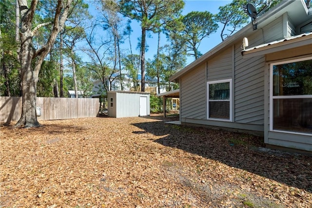 view of yard with a storage shed, fence, and an outdoor structure