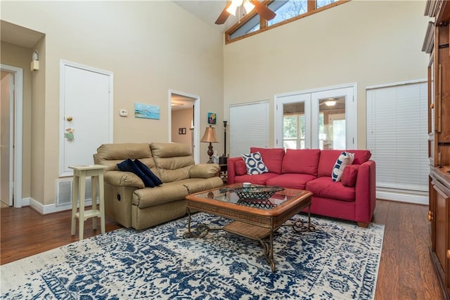 living area featuring french doors, visible vents, dark wood-type flooring, ceiling fan, and high vaulted ceiling