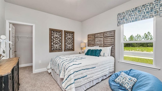 carpeted bedroom with a closet and a walk in closet