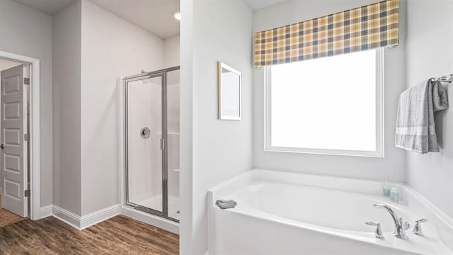 bathroom with hardwood / wood-style flooring and independent shower and bath