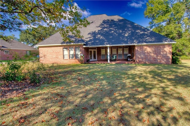 rear view of house featuring a patio, a yard, and french doors