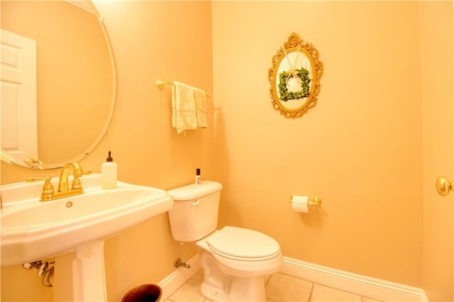 bathroom featuring toilet, sink, and tile patterned floors