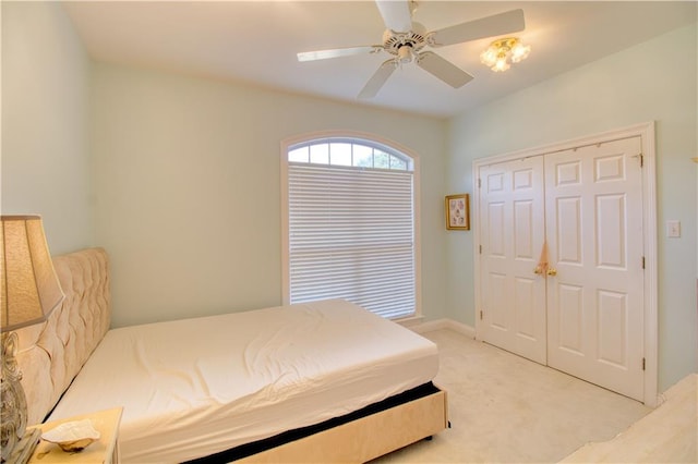 bedroom featuring a closet, light carpet, and ceiling fan