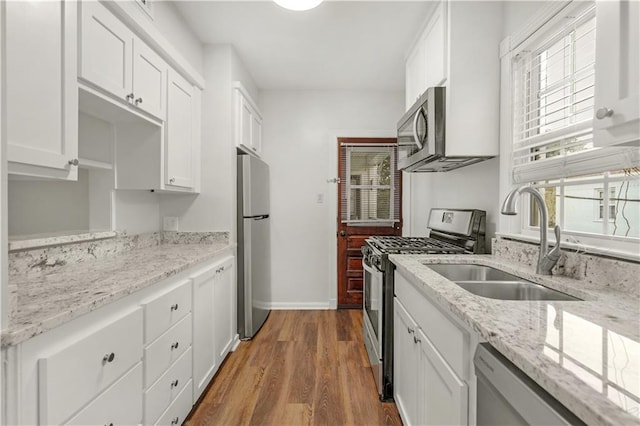 kitchen featuring hardwood / wood-style floors, appliances with stainless steel finishes, and white cabinetry