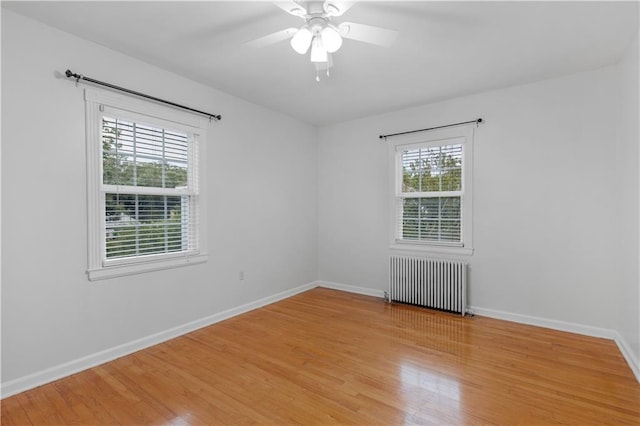 spare room featuring ceiling fan, light hardwood / wood-style flooring, and radiator