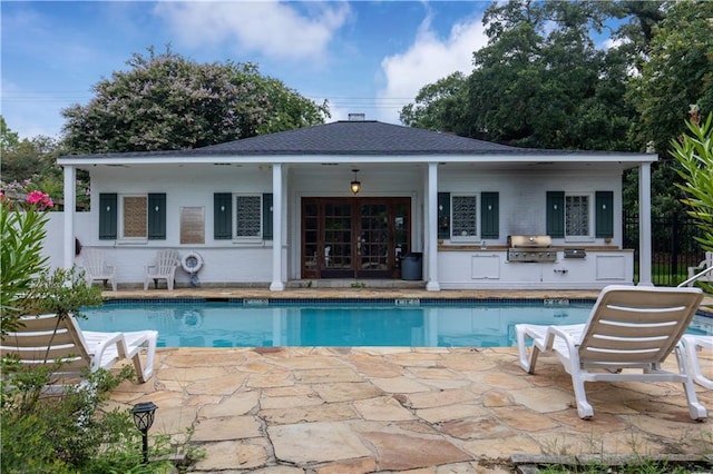 view of swimming pool featuring exterior kitchen, area for grilling, and a patio area