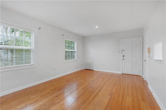 empty room featuring light hardwood / wood-style flooring and radiator heating unit