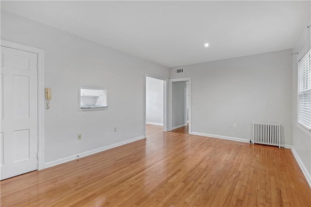 empty room featuring light hardwood / wood-style flooring and radiator