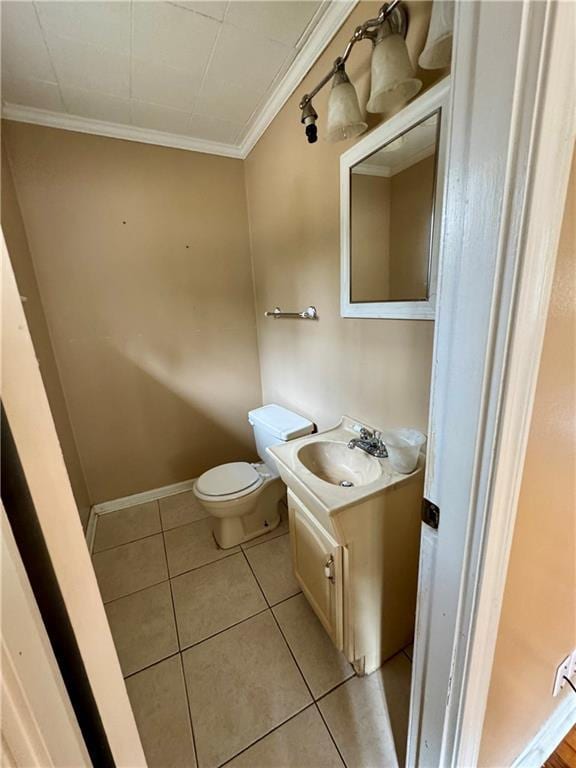 bathroom with tile patterned flooring, vanity, crown molding, and toilet