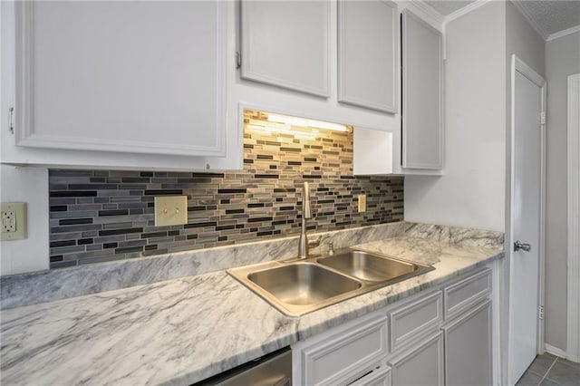 5717 Post Oak Ct, Mobile, AL 36609 - kitchen featuring a sink, crown molding, backsplash, and white cabinets