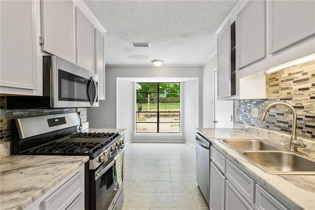 5717 Post Oak Ct, Mobile, AL 36609 - kitchen with stainless steel appliances, a sink, tasteful backsplash, light tile patterned flooring, and baseboards