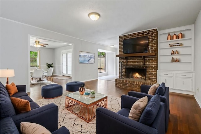 5717 Post Oak Ct, Mobile, AL 36609 - living room featuring dark wood-style floors, a fireplace, a ceiling fan, and built in shelves