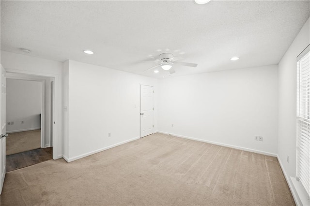 empty room featuring ceiling fan and light colored carpet