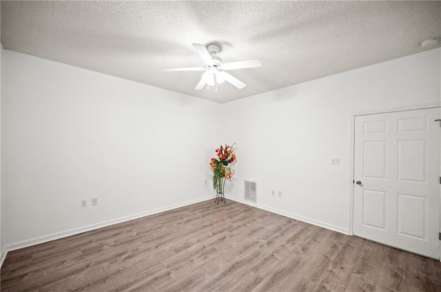 unfurnished room with a textured ceiling, light hardwood / wood-style flooring, and ceiling fan