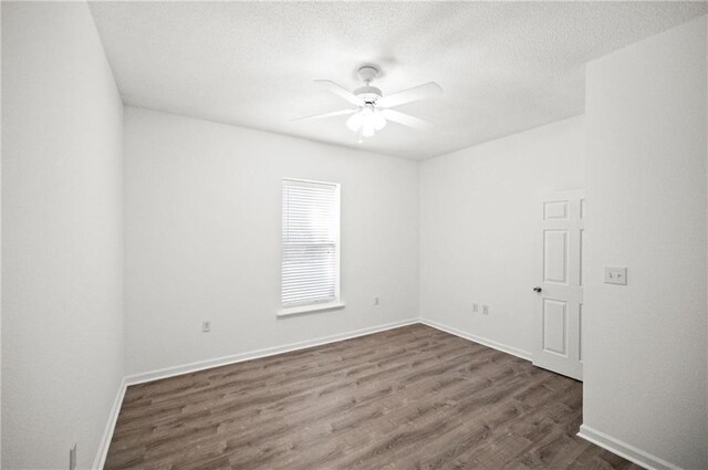 spare room featuring dark hardwood / wood-style floors, a textured ceiling, and ceiling fan