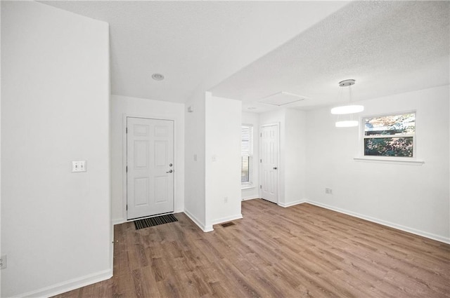 unfurnished room with hardwood / wood-style floors and a textured ceiling