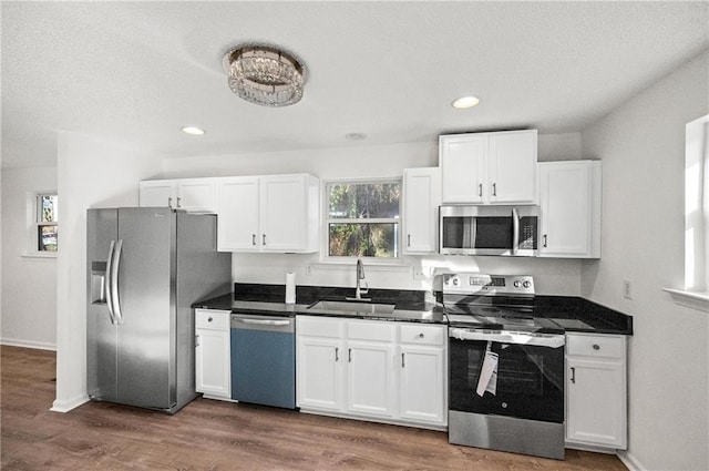 kitchen featuring white cabinetry, appliances with stainless steel finishes, dark wood-type flooring, and sink