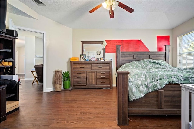 bedroom featuring dark hardwood / wood-style floors, ceiling fan, and a textured ceiling