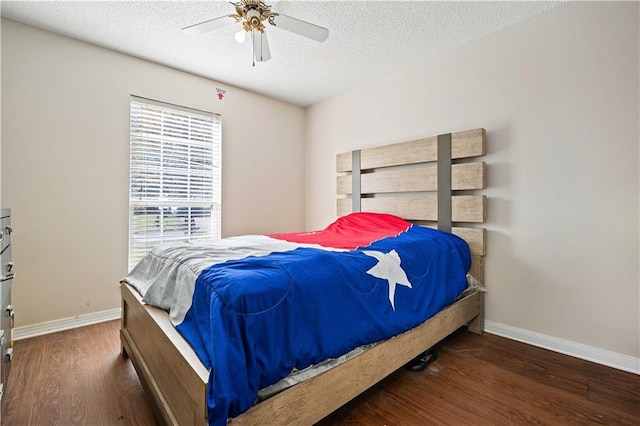 bedroom with ceiling fan, dark hardwood / wood-style flooring, and a textured ceiling