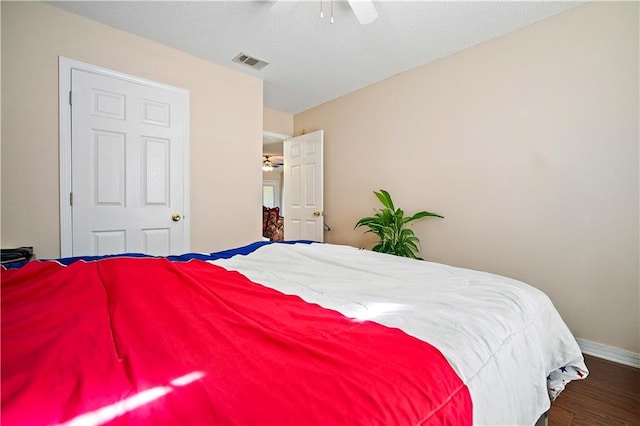 bedroom with dark hardwood / wood-style floors and ceiling fan