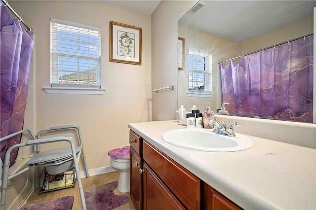 bathroom featuring walk in shower, vanity, and toilet