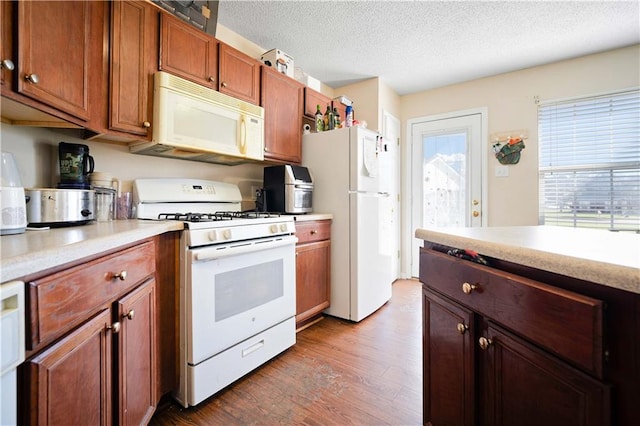 kitchen with a textured ceiling, hardwood / wood-style floors, and white appliances