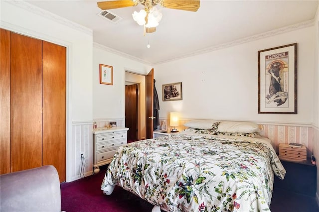 carpeted bedroom with ceiling fan, ornamental molding, and a closet