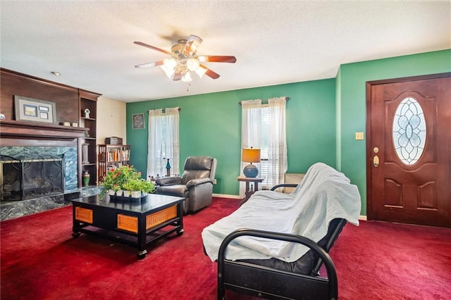 carpeted living room featuring ceiling fan, a fireplace, and a textured ceiling