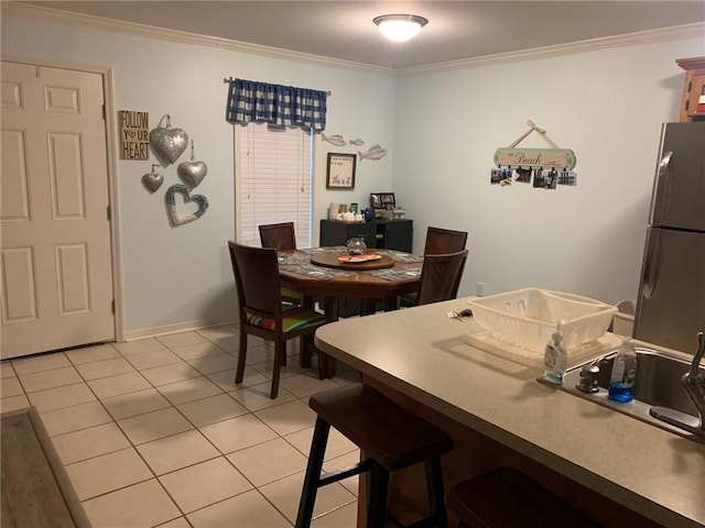 dining room featuring light tile patterned floors and ornamental molding