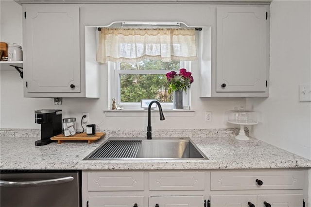 kitchen with dishwasher, white cabinets, and a sink