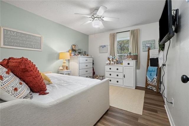 bedroom with baseboards, a textured ceiling, wood finished floors, and a ceiling fan