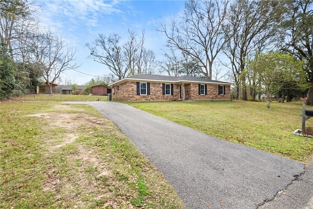 single story home with a front lawn and aphalt driveway