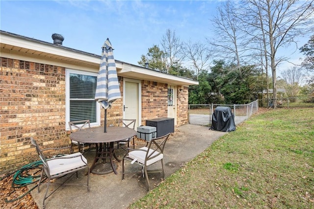 view of patio with a gate, outdoor dining area, and fence