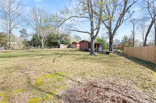 view of yard with a shed, an outdoor structure, and fence