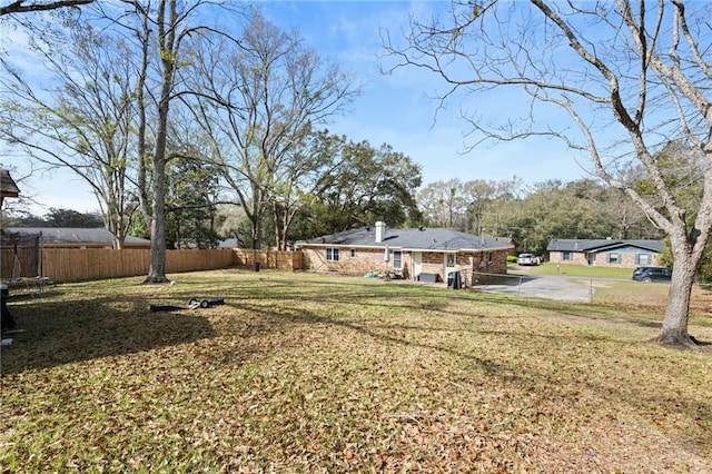 view of yard featuring a trampoline and fence