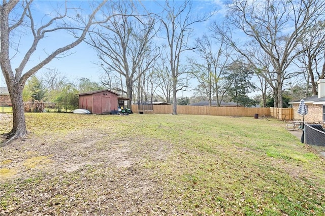 view of yard featuring an outbuilding, a storage unit, and a fenced backyard