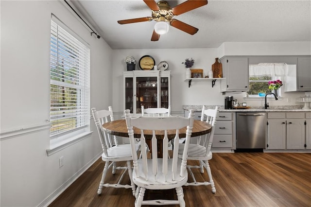 dining area with a wealth of natural light, baseboards, ceiling fan, and dark wood-style flooring