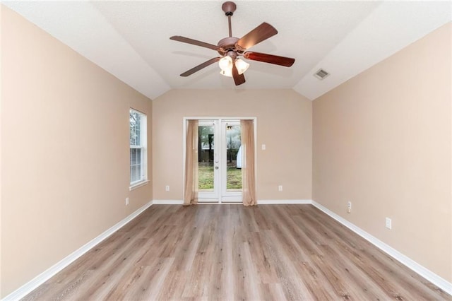 empty room featuring ceiling fan, vaulted ceiling, and light wood-type flooring