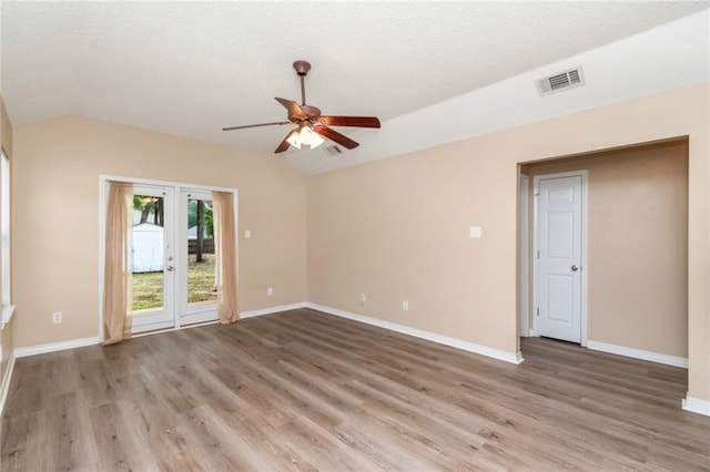 spare room featuring vaulted ceiling, wood-type flooring, ceiling fan, and french doors