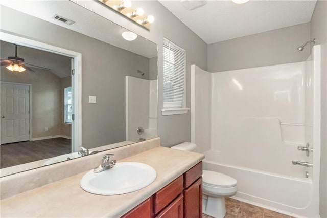 full bathroom with shower / washtub combination, vanity, ceiling fan, and toilet