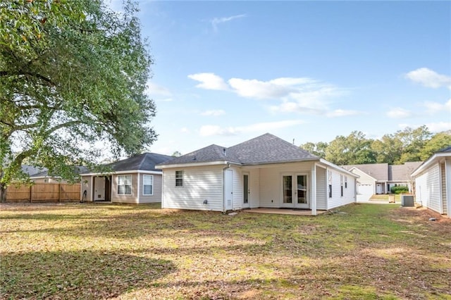 rear view of property featuring a yard and central air condition unit