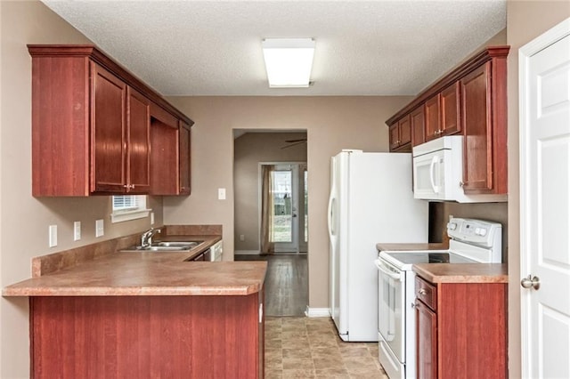 kitchen featuring white appliances, kitchen peninsula, sink, and a textured ceiling