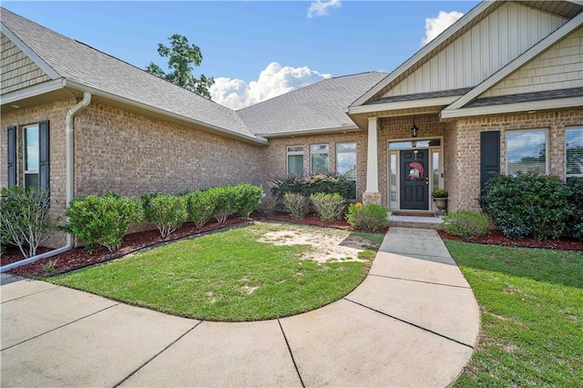 view of exterior entry featuring a lawn