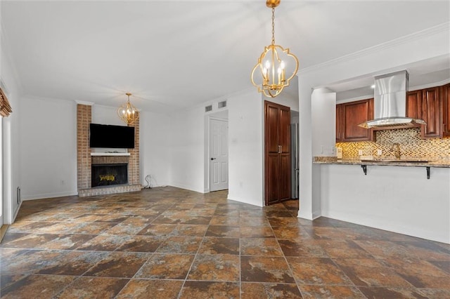 2901 Grant St Unit 601, Mobile, AL 36606 - unfurnished living room with a chandelier, stone tile floors, a brick fireplace, and ornamental molding